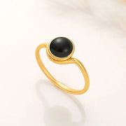 14k Gold filled ring with a black onyx gemstone on a light beige background
